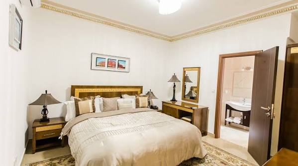 Chambre standard avec lit double, tête de lit dorée et salle de bain attenante