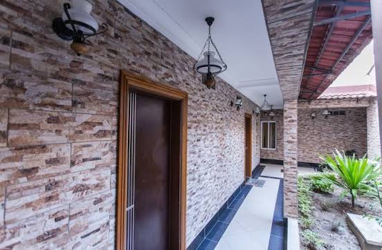 Couloir en pierre de la résidence, menant aux chambres, avec luminaires en fer forgé